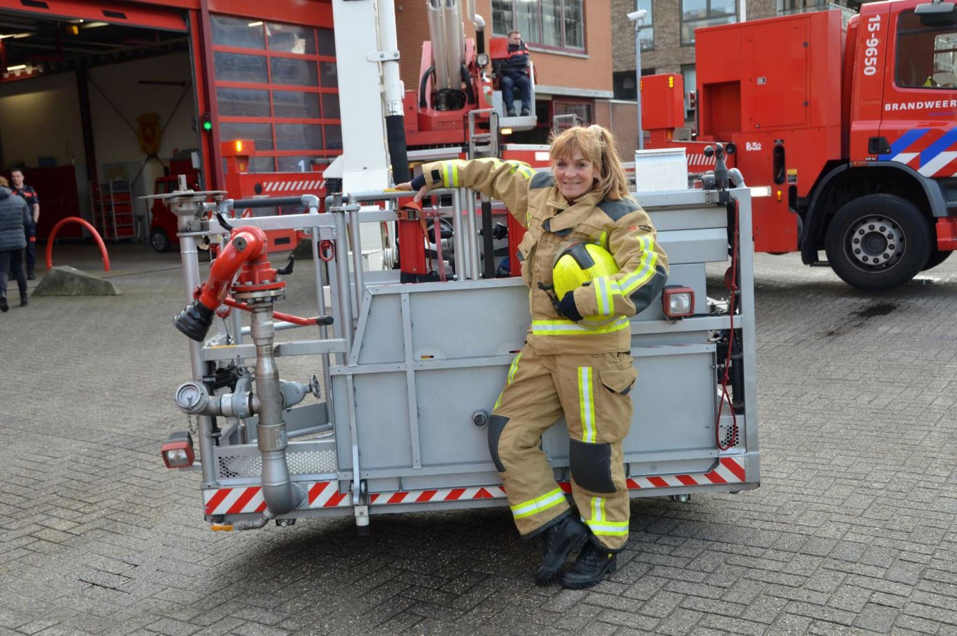 Brandweervrouw Els Nelis poseert bij hoogwerker