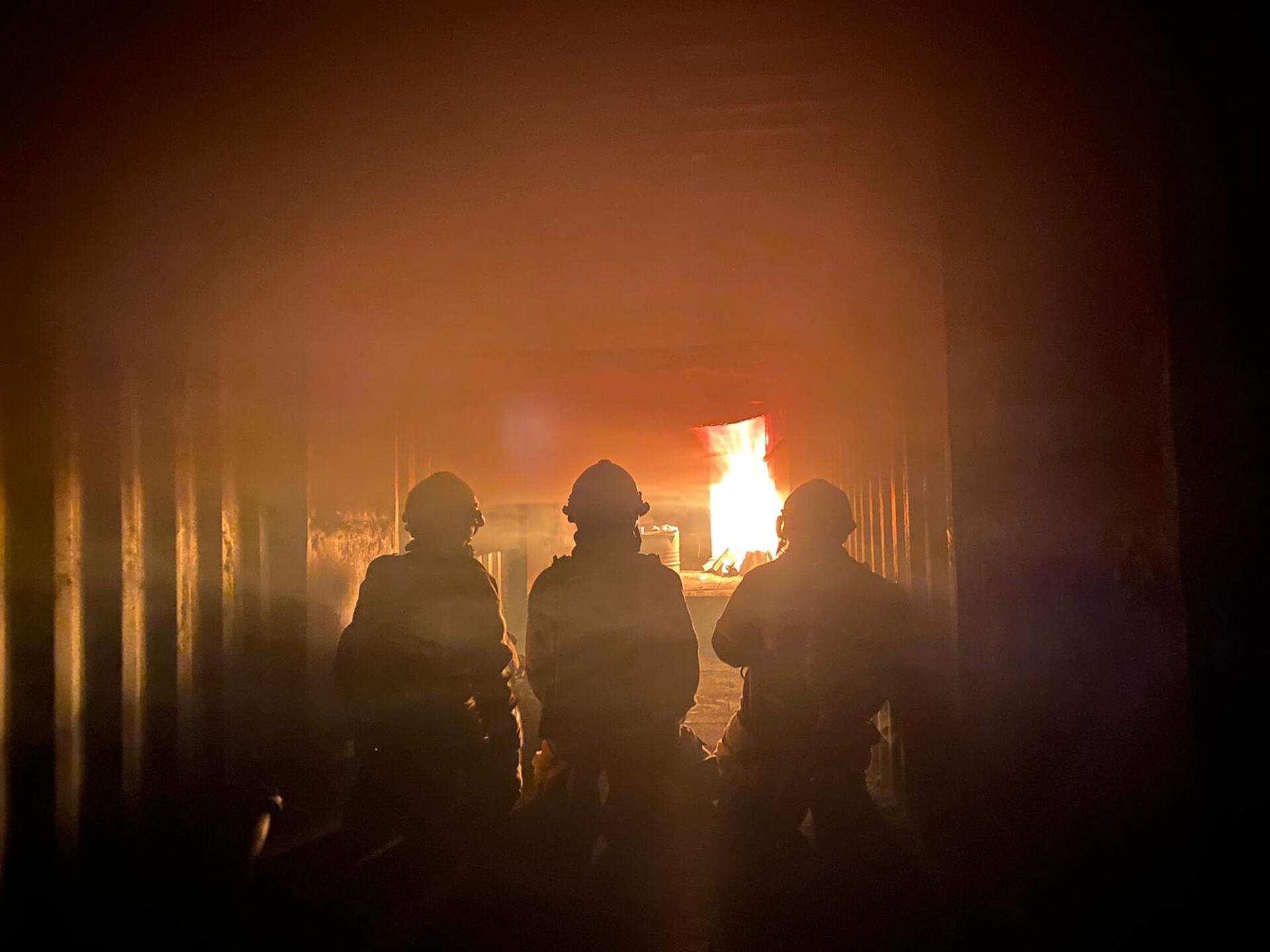 Brandweermannen bij een brand oefening in een container
