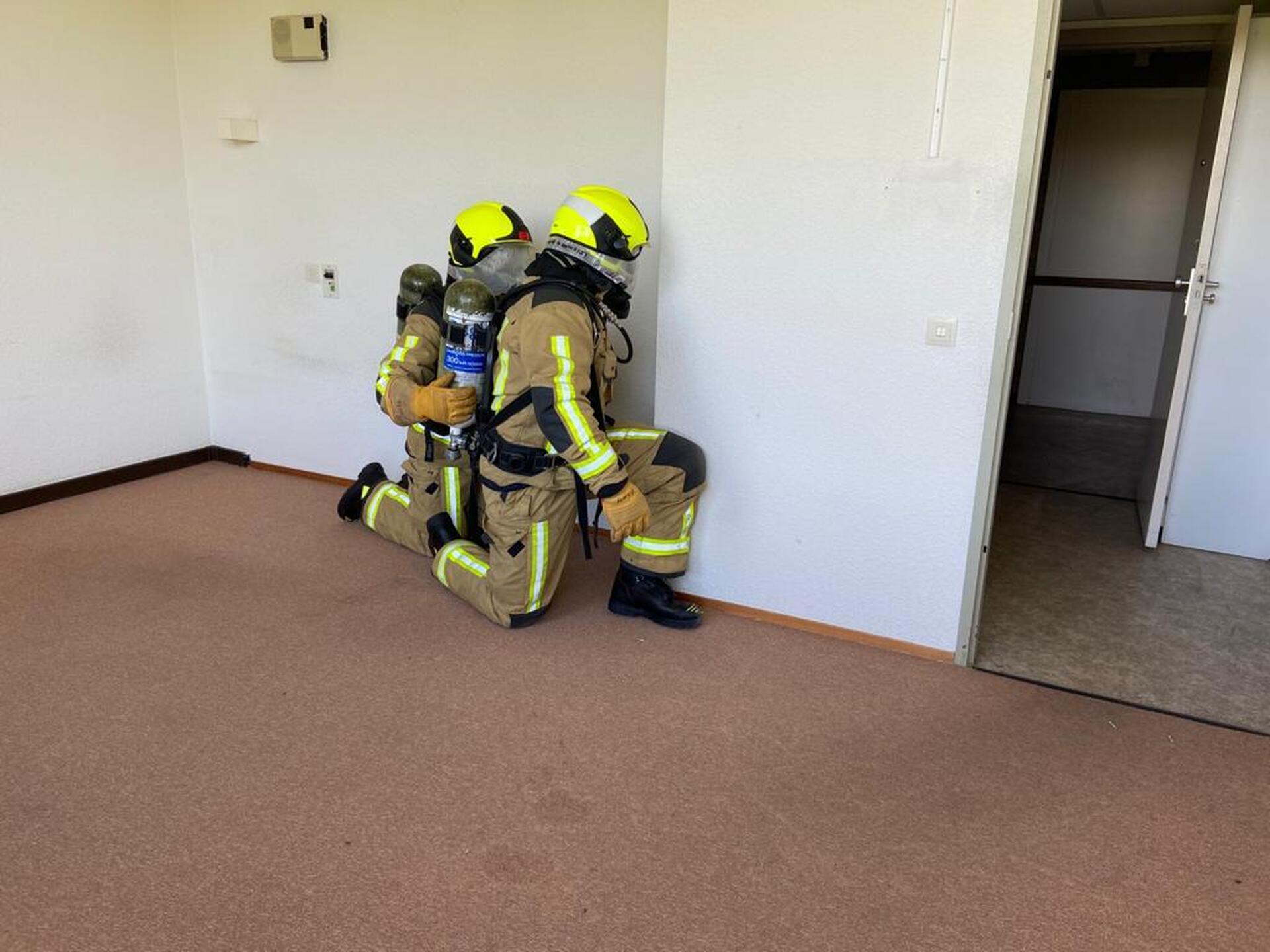 Twee brandweermannen tijdens een oefening 'Blind verkennen'