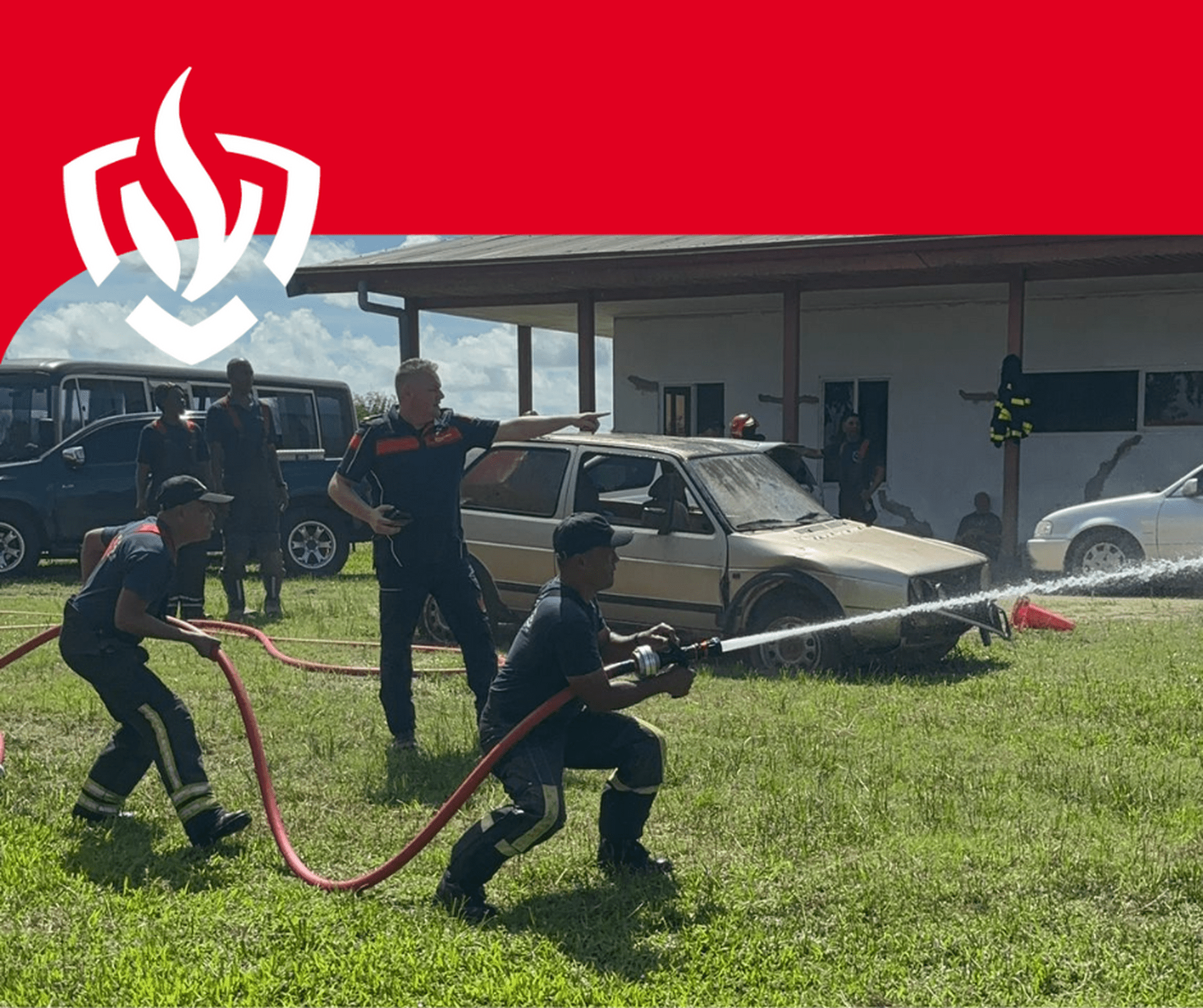Twee Surinaamse brandweermannen oefenen met straalpijp onder toeziend oog van instructeur