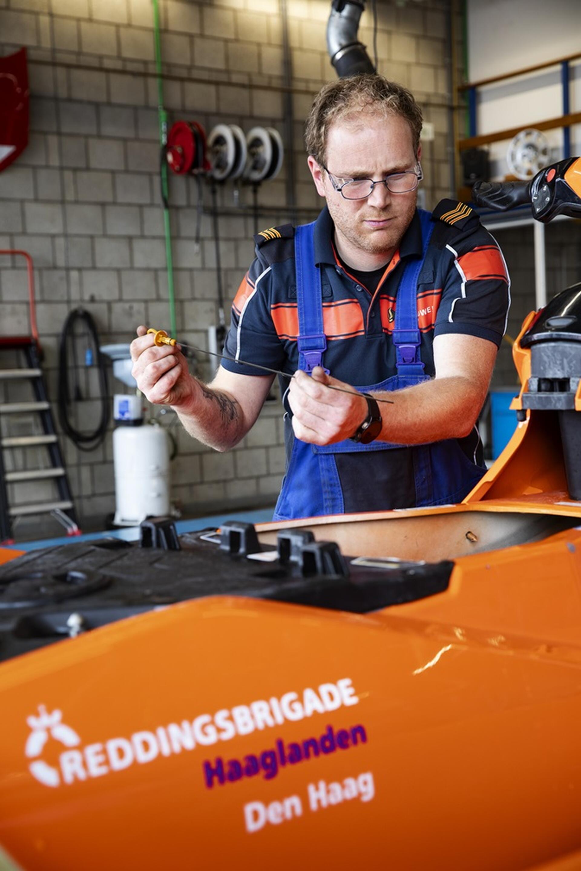 Rutger werkt aan voertuig van de reddingsbrigade