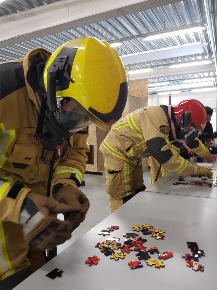 Brandweermannen leggen een puzzel