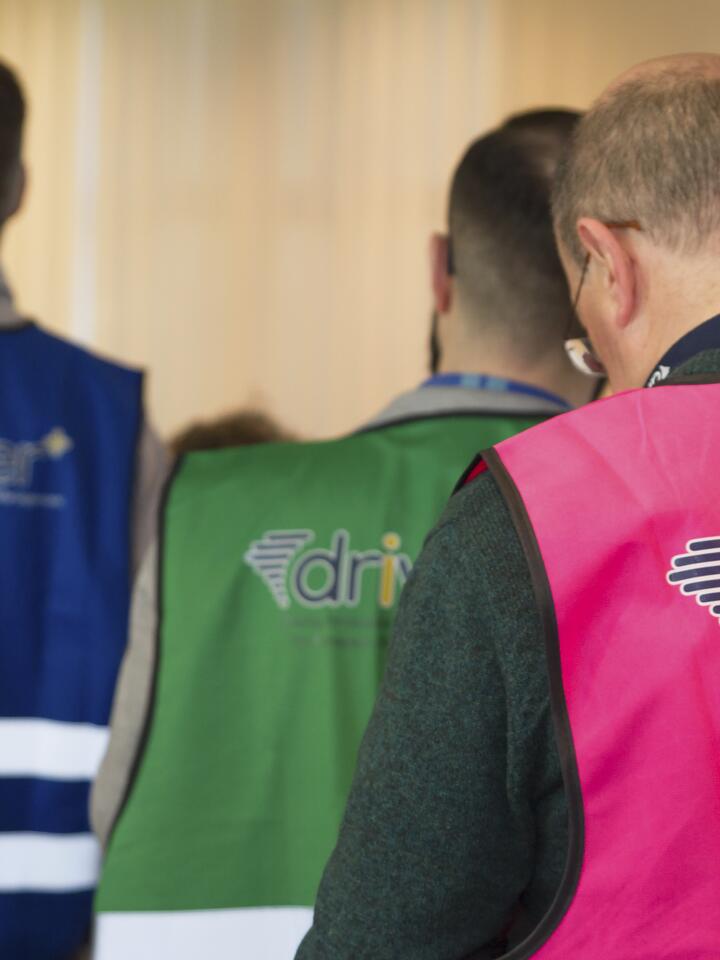Deelnemers aan Driver Trial met veiligheidshesjes