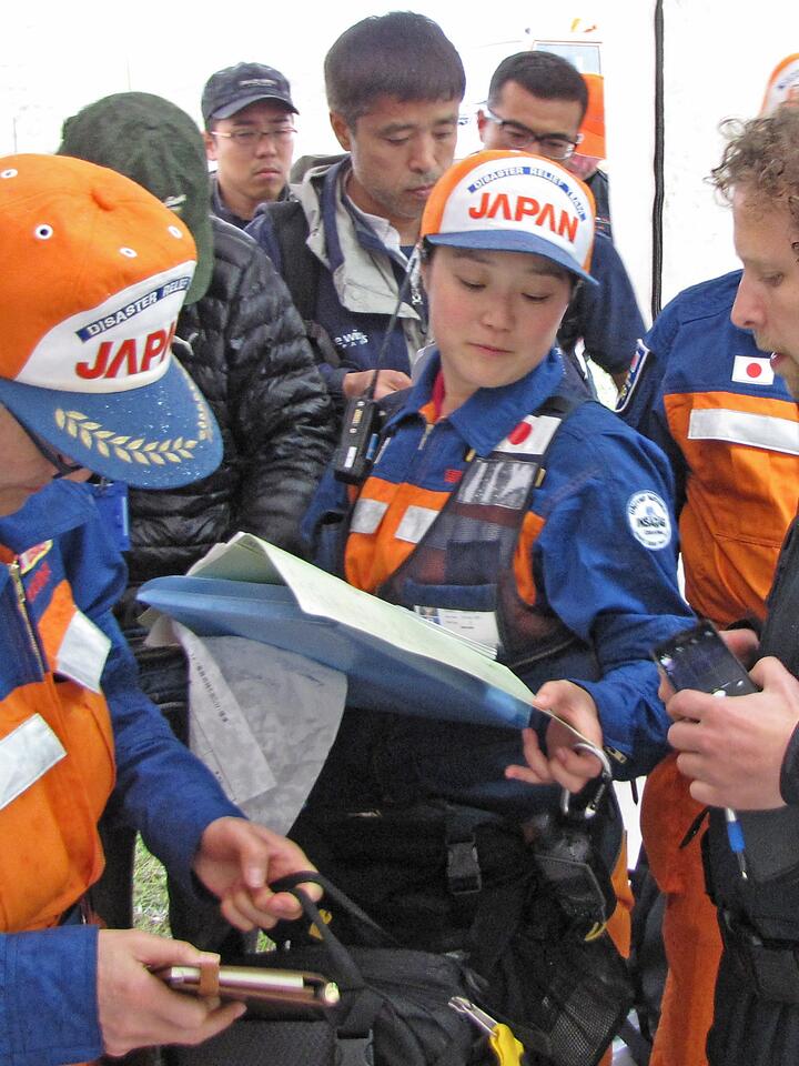 Een groepje Japanse hulpverleners in overleg