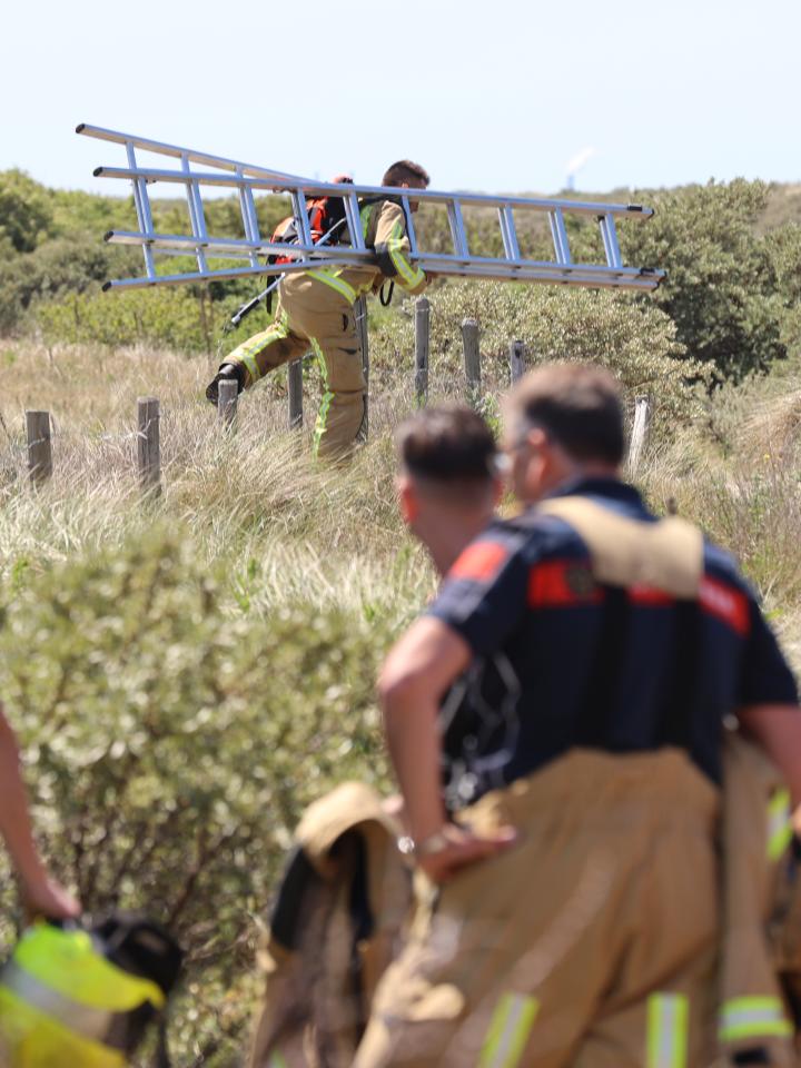 Brandweermensen van Brandweer Haaglanden bezig met het blussen van een duinbrand
