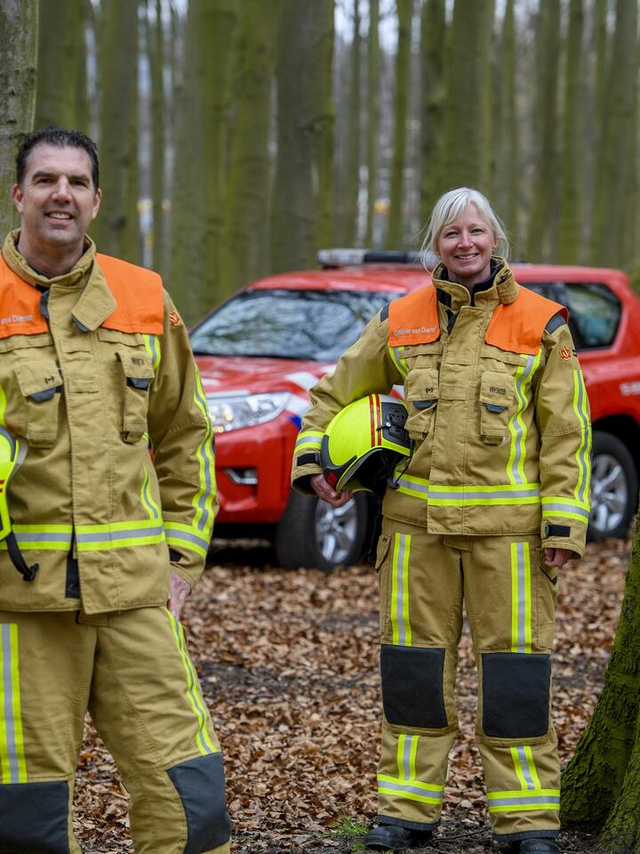 Marco en Miriam, officieren van dienst, op de foto in een bos met de bedrijfsvoertuig