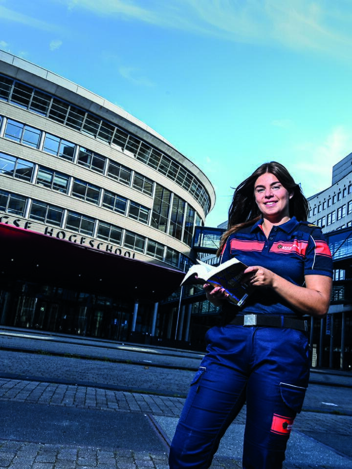 Vrouw in brandweer uniform voor de haagse hoge school.