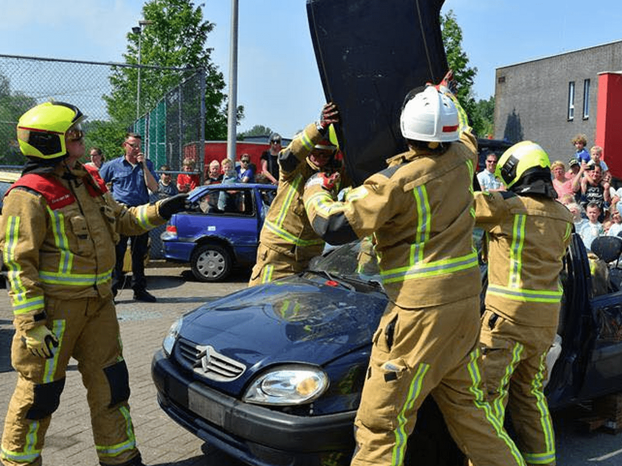 Brandweermannen halen dak van auto af