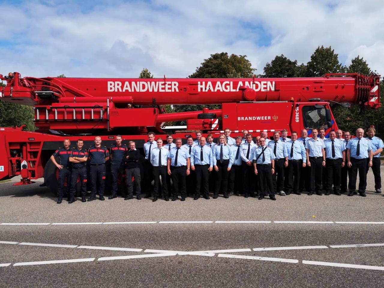 Duitse en Nederlandse brandweercollega's poseren voor brandweerauto