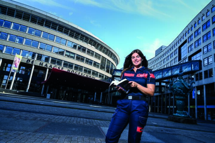 Vrouw in brandweer uniform voor de haagse hoge school.
