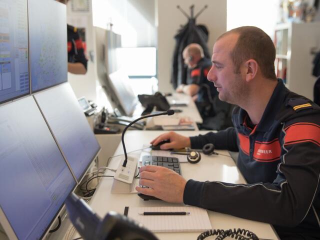 Man in meldkamer aan het werk
